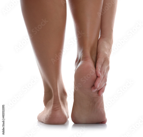 Back view of woman suffering from foot pain on white background, closeup