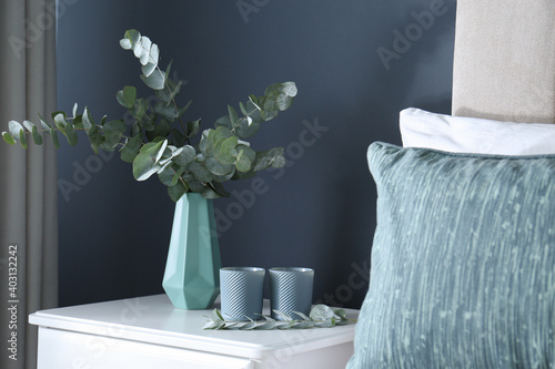 Papier peint Beautiful eucalyptus branches and candles on nightstand in bedroom
