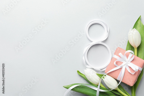 8 March card design with tulips, gift and space for text on light grey background, flat lay. International Women's Day photo