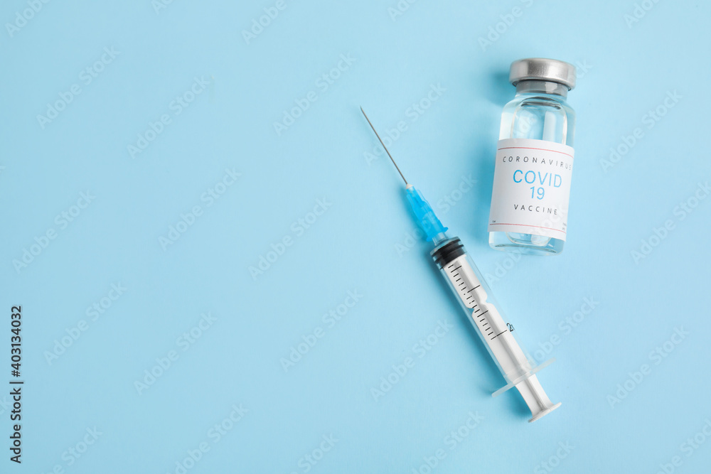 Vial with coronavirus vaccine and syringe on light blue background, flat lay. Space for text Vial with coronavirus vaccine and syringe on light blue background, flat lay. Space for text