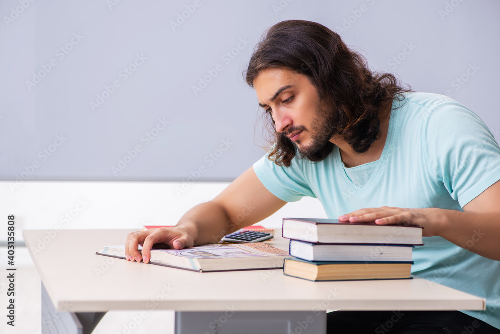 Young male student preparing for exams in the classroom Young male student preparing for exams in the classroom