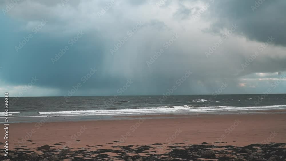 Grey storm rain clouds over an empty beach with waves crashing in South Shields, UK. Grey storm rain clouds over an empty beach with waves crashing in South Shields, UK.