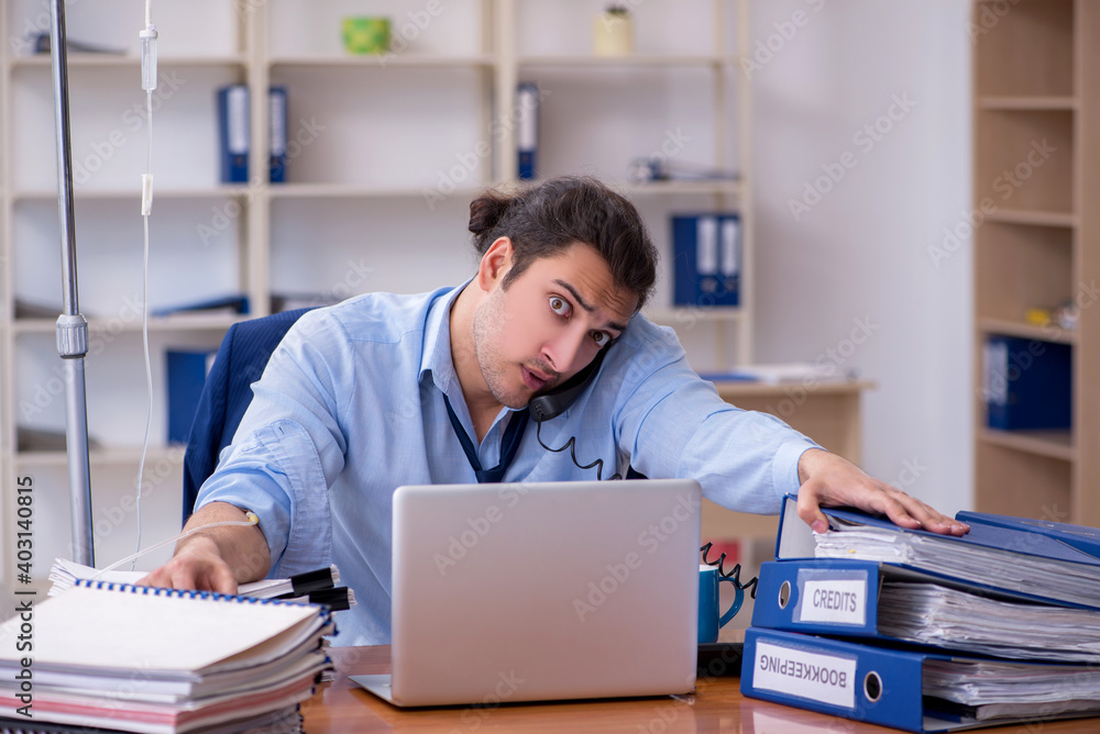Young male employee suffering at workplace Young male employee suffering at workplace