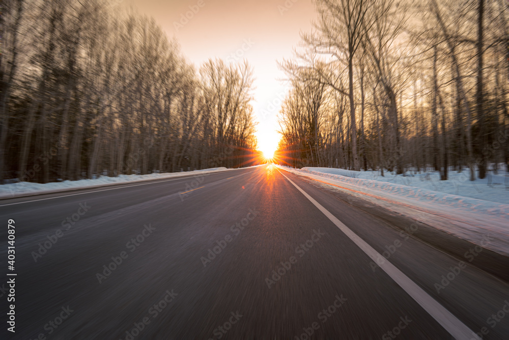 Driving toward a winter sunset on a rural highway