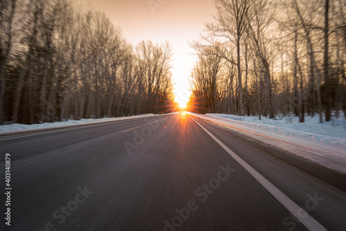 Driving toward a winter sunset on a rural highway