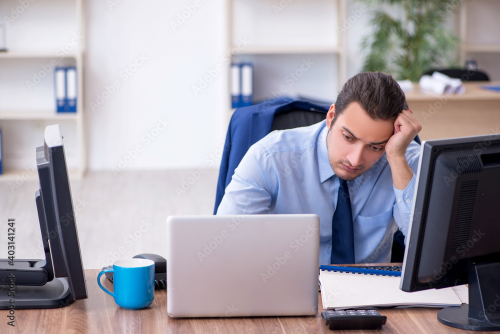 Young male employee unhappy with excessive work Young male employee unhappy with excessive work