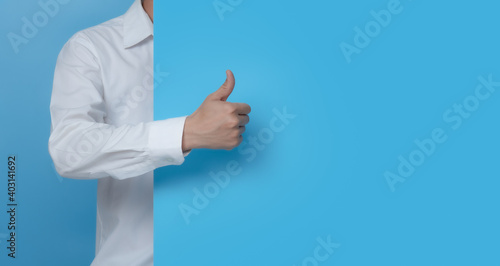 Male hand showing thumbs up on blue background,copy space for text