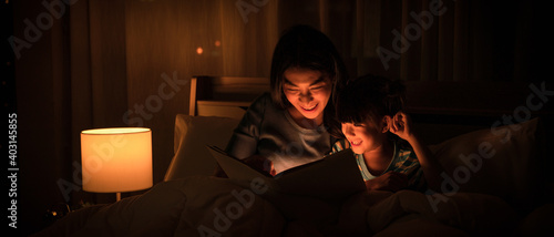 mom and daughter have goodtime reading bedtime stories for daughter