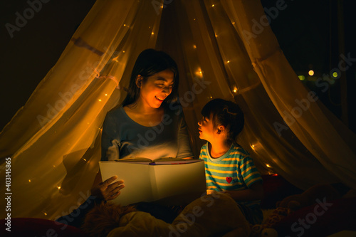 Foto mom and daughter read bedtime stories fairytale together before going to bed