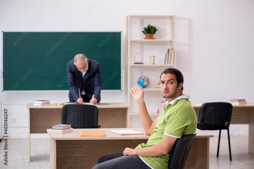 Aged teacher and male lazy student in the classroom Aged teacher and male lazy student in the classroom