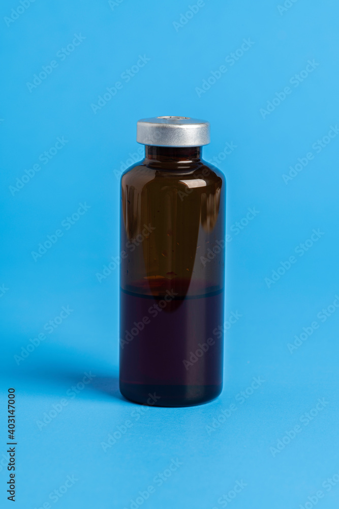 Macro Image Of Amber Vaccine Vial In Blue Background Macro Image Of Amber Vaccine Vial In Blue Background