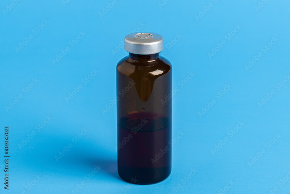 Macro Image Of Amber Vaccine Vial In Blue Background Macro Image Of Amber Vaccine Vial In Blue Background