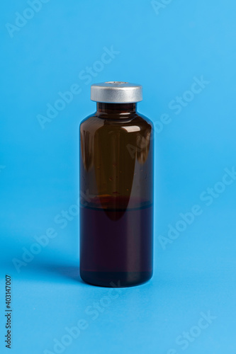 Macro Image Of Amber Vaccine Vial In Blue Background