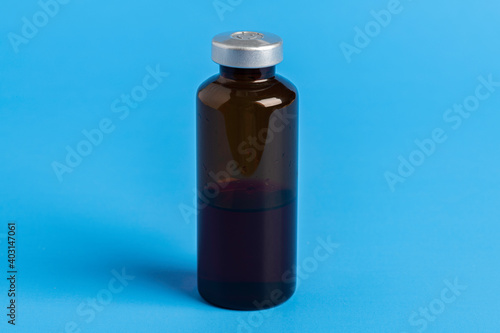 Macro Image Of Amber Vaccine Vial In Blue Background
