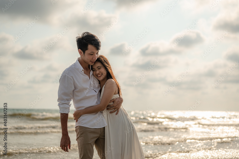 Young couple embracing on the beach in the sunset.Summer in love,Valentine day concept.