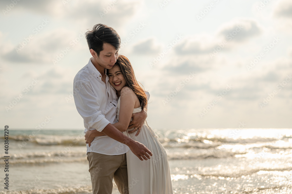 Young couple embracing on the beach in the sunset.Summer in love,Valentine day concept. Young couple embracing on the beach in the sunset.Summer in love,Valentine day concept.