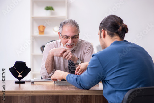 Fotografija Young man visiting old male jeweler