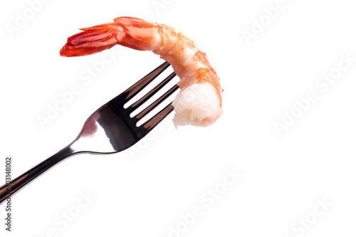 A large cooked peeled tiger shrimp on a fork for dipping in cocktail sauce