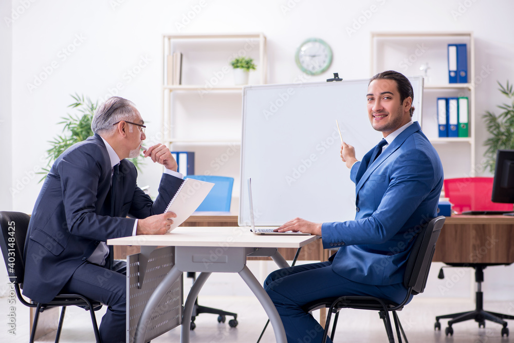 Yound and old employees in business presentation concept