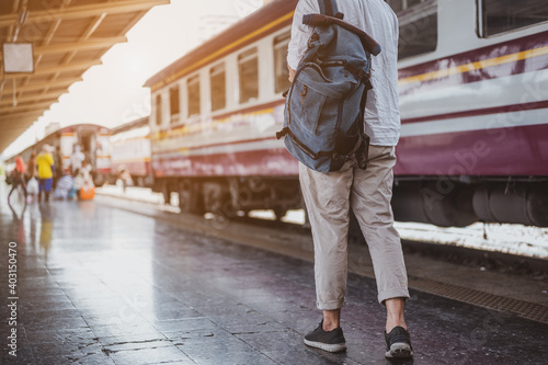 Asian man traveler with backpack in the railway, Backpack at the train station with a traveler. Travel concept. Man traveler tourist walking at train station.