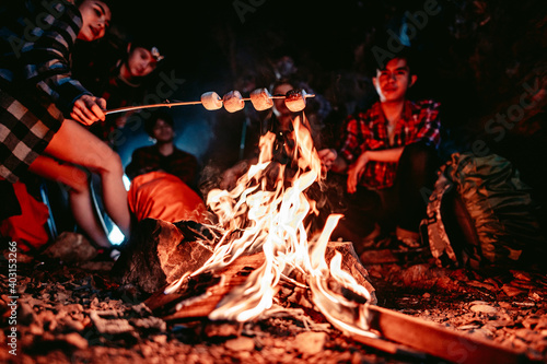A group of hikers set up a fire to cook food in a cave at night.Adventure and camping.Teamwork,Travel Concept.