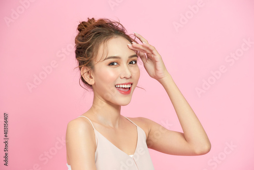 Beauty portrait of young asian woman with a beautiful smile, over a pink background