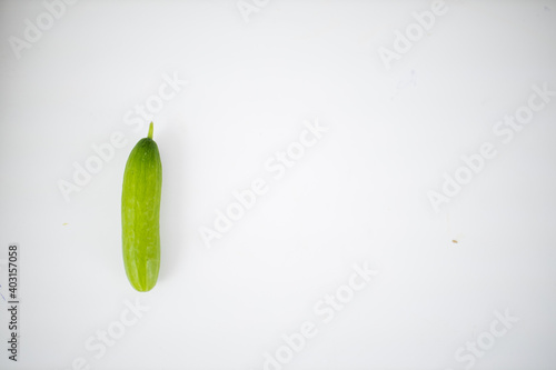 Fresh cucumber isolated lying on a white table