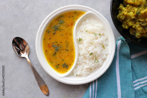 Healthy nutritious Indian comfort food Dal Chawal thali or Dal Rice. Served in two way ceramic plate. Over white background with copy space. photo