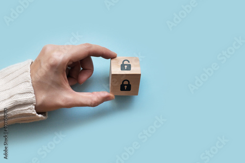 Wooden cube with an open and closed lock pattern. Day of protection of personal data. Protection of personal information