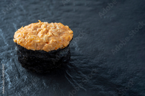 spicy guncan with chicken and spicy sauce on a dark textured surface. Side view, copy space photo