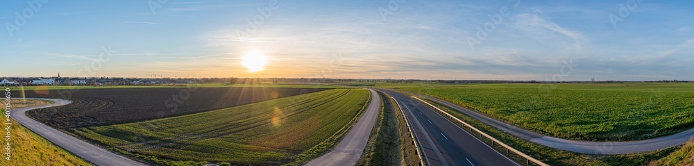beautiful panorama sunrise over the sown fields and highway of a landside in Heinsberg germany