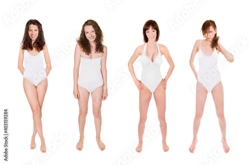Full length portraits of four attractive young women wearing white swimsuits, isolated on neutral studio background