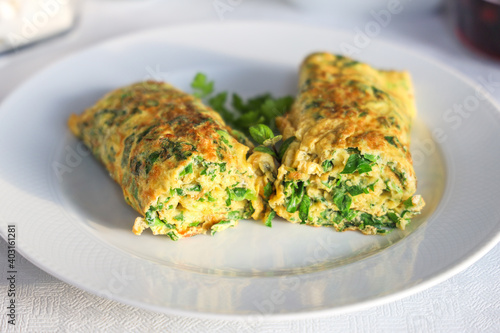 Egg omelette rolled with vegetables on a plate. White Background.
