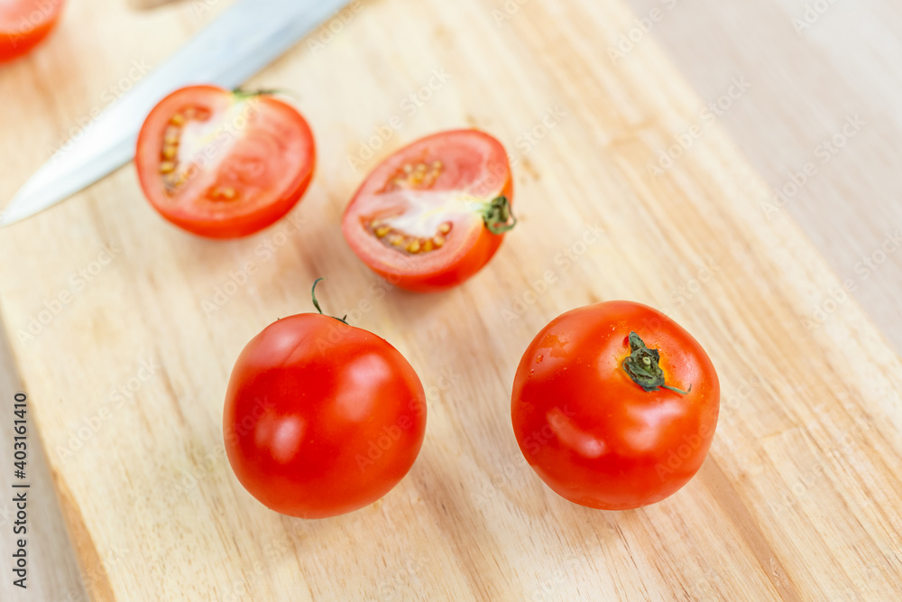 red tomatoes and slices on wooden cutting board red tomatoes and slices on wooden cutting board