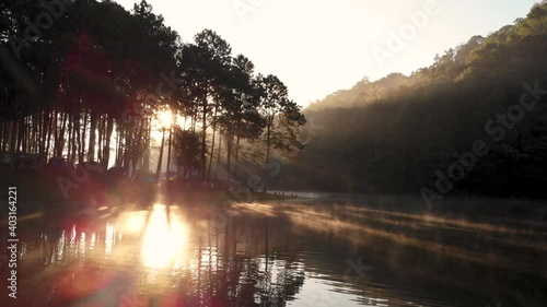 Amazing Morning sunlight at Pang Ung lake with Rowing boat and fog floating above the water surface, Pang Ung travel destination at Mae Hong Son province Thailand. Slide slowly left to right by drone.
