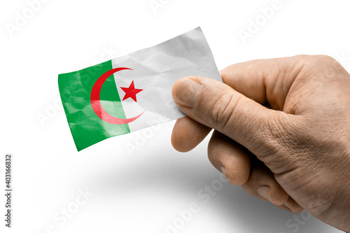 Hand holding a card with a national flag the Algeria