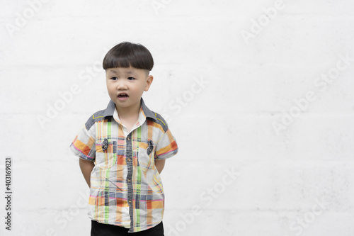Studio shot portrait of happy little Asian boy on background