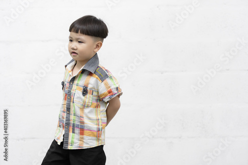 Studio shot portrait of happy little Asian boy on background