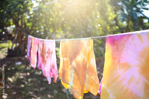 Natural color dye t-shirt hanging on plastic rope at the garden, outdoor day light, natural color dyeing workshop in Thailand