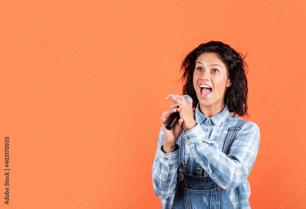 Fototapeta premium happy pretty woman with brunette hair wear casual clothes sing song in microphone, copy space, music