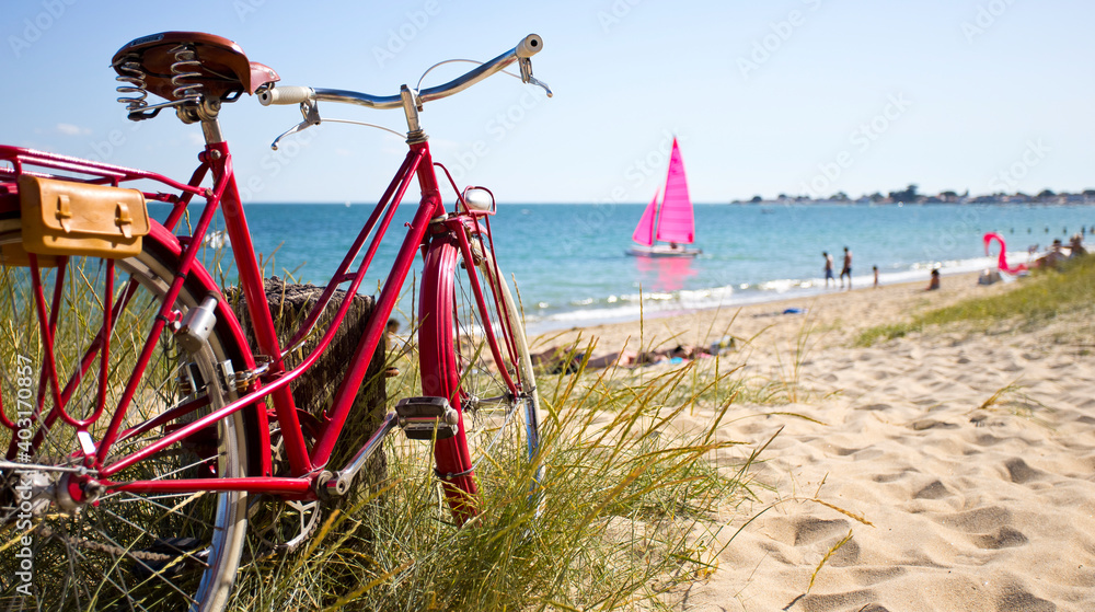 Obraz na płótnie Vélo rouge en bord de mer sur une plage en France. w salonie
