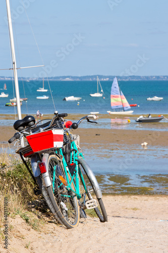 Paysage de bord de mer en France, vélo et bateau sur la plage.