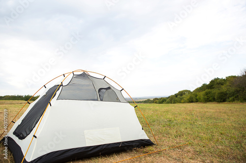 Installed tourist tent in nature in the forest. Domestic tourism, active summer holidays, family adventures. Ecotourism, social distance. Copy space