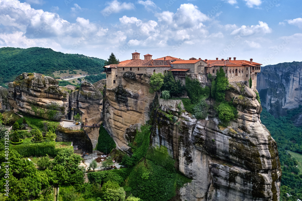 Cliff top Varlaam monastery in Meteora, Greece in typical Meteora landscape of rocky pillars and slopes, spring foliage. UNESCO World Heritage