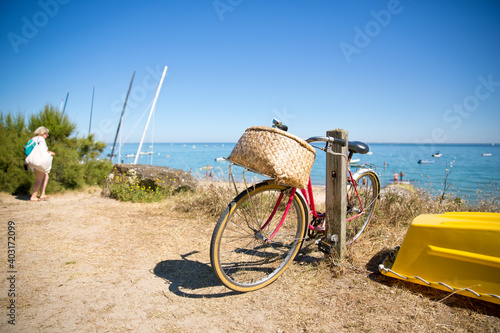 Vieux vélo rouge en bord de mer sur l'île de Noirmoutier en Vendée.