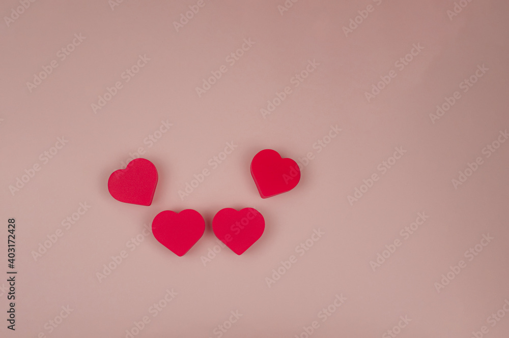 Four red hearts on a pink background