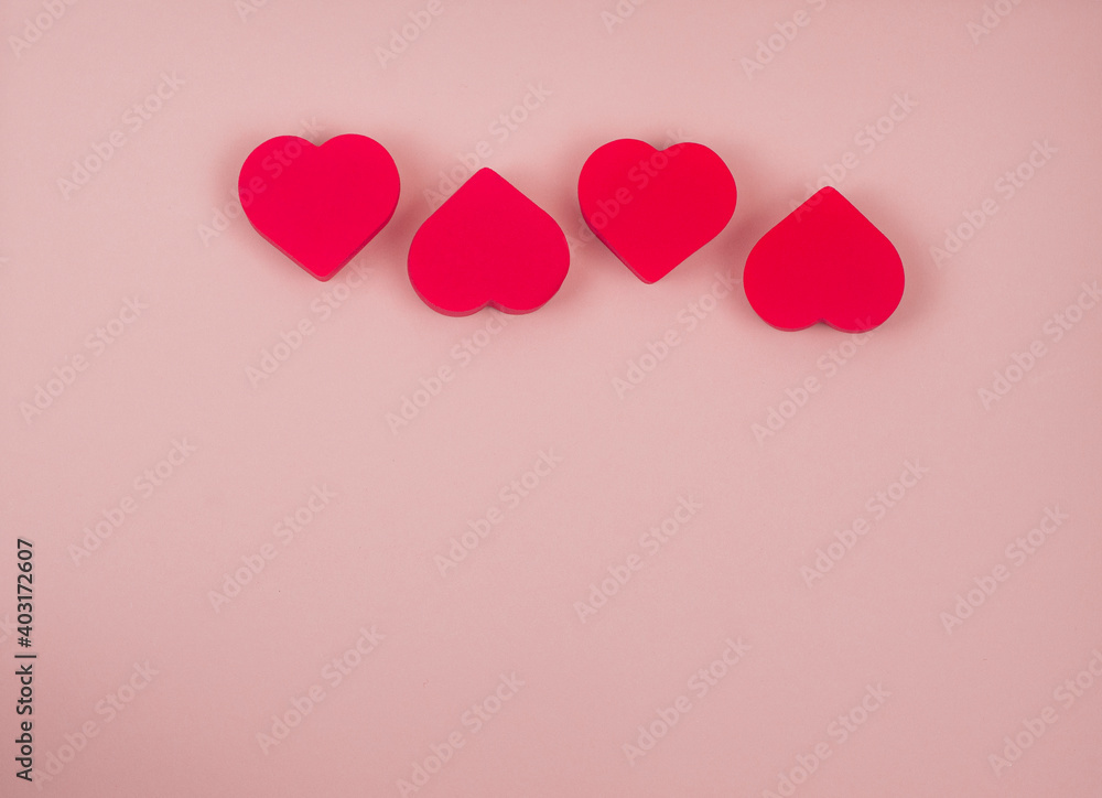 Four red hearts on a pink background