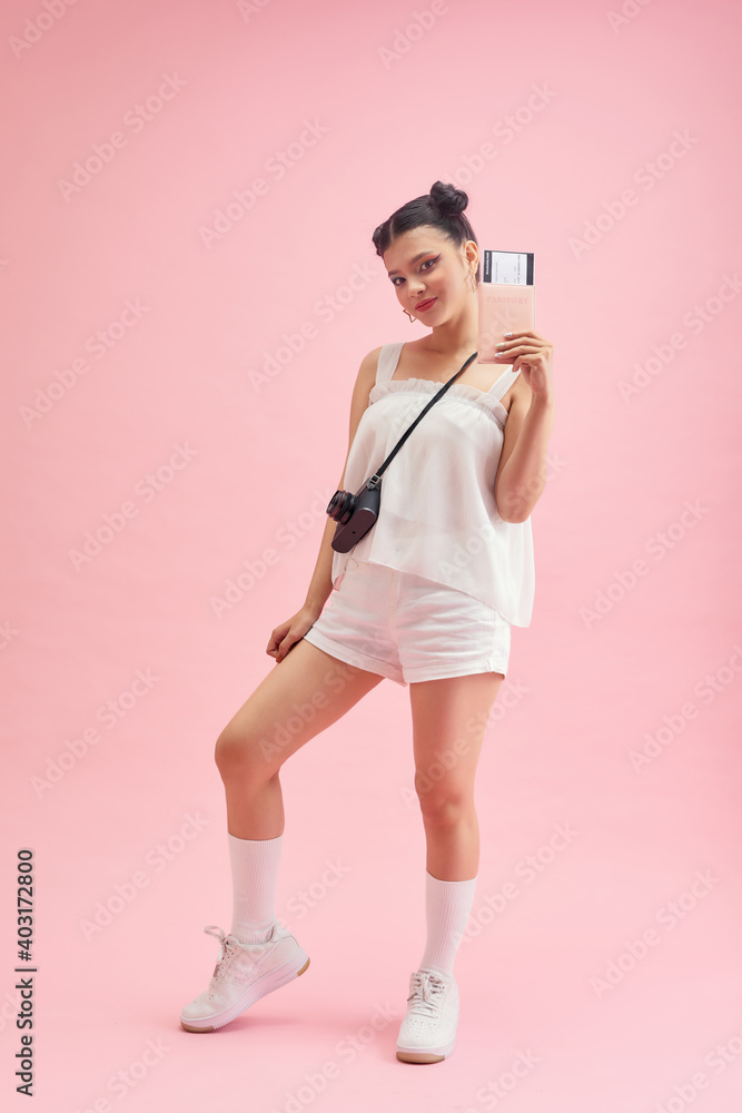 Tourist woman in summer casual clothes.Asian Smiling woman .Passenger traveling abroad to travel on pink background Tourist woman in summer casual clothes.Asian Smiling woman .Passenger traveling abroad to travel on pink background