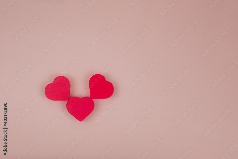  three red hearts on a pink background