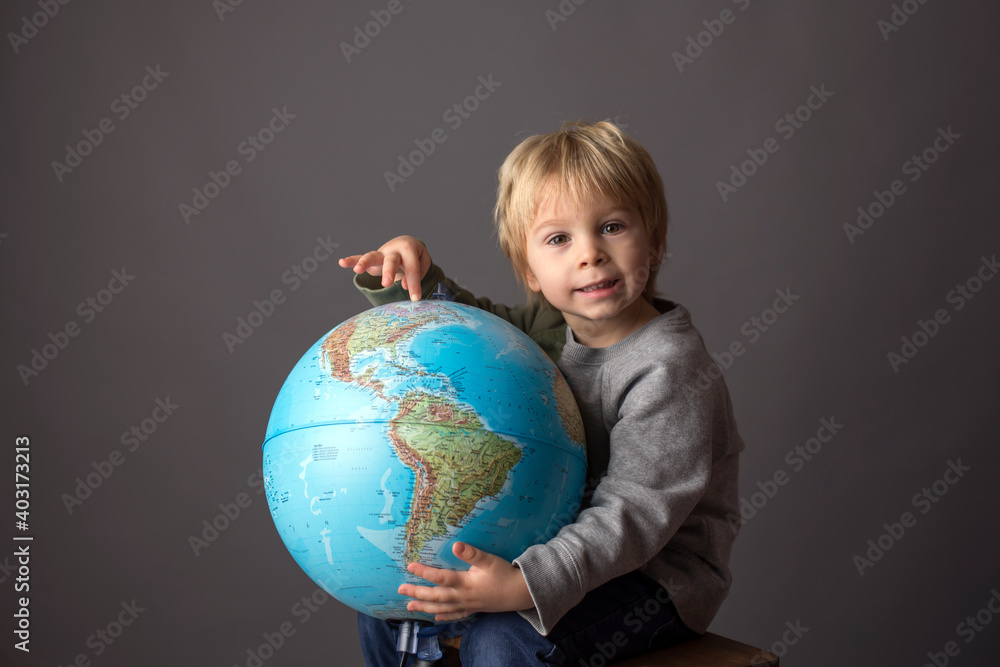 Cute toddler child, boy, hugging big globe, isolated image Cute toddler child, boy, hugging big globe, isolated image